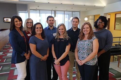 New faculty lined up in two rows in the library