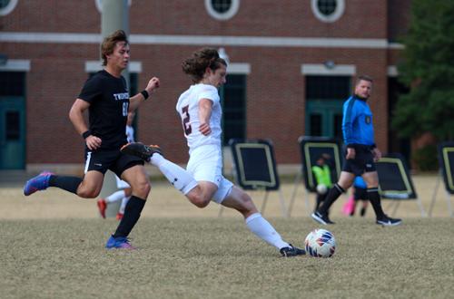 Men's soccer player running and about to kick the ball